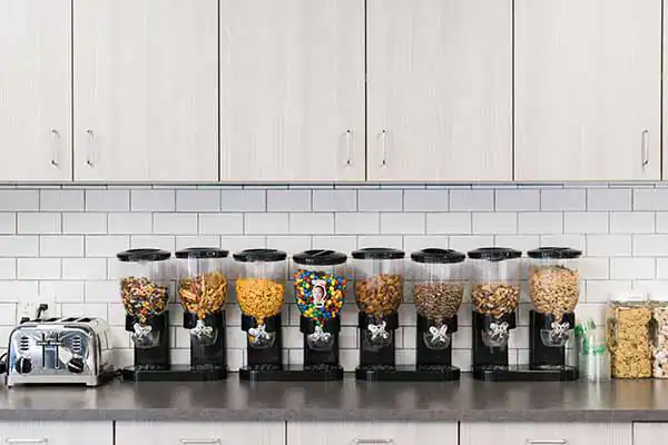 A row of snack dispensers with various nuts and chips in the Name.com kitchen