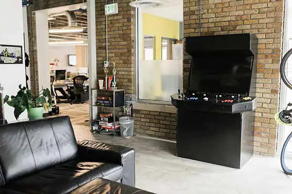 A standnding 4-person arcade machine and couch in the Name.com office