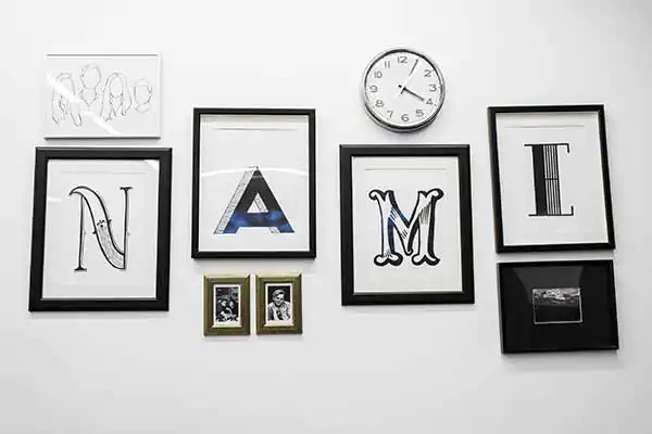 A series of picture frames on a wall that have the letters that spell out Name