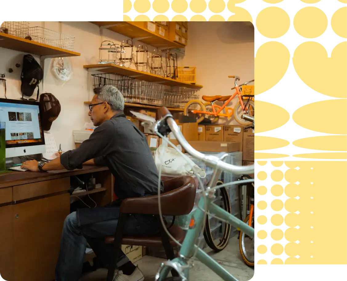 Man sits at desk in bike shop looking at computer screen