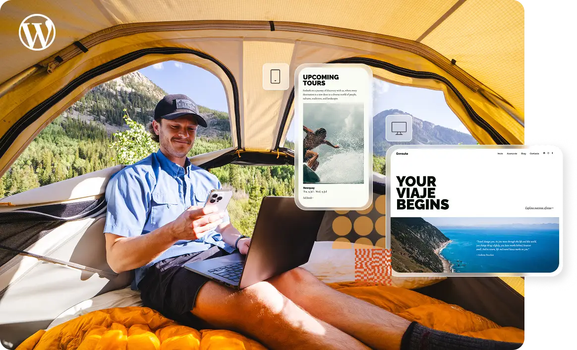 A man sits on top of a sleeping bag inside a tent with a laptop on his lap